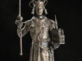 a silver statue of a man holding a sword and a shield