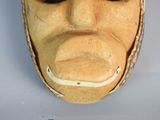 a wooden mask that has a face on it