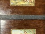 Deux tableaux représentant un homme et une femme sont posés sur une table.