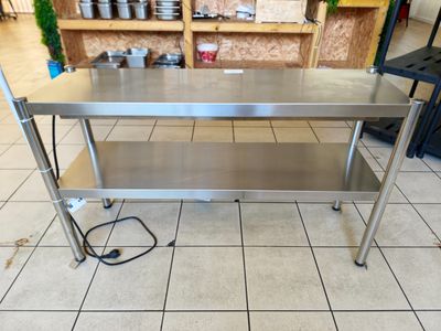 une table en acier inoxydable posée sur un sol carrelé