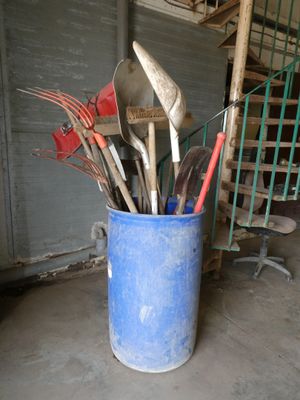 de nombreux ustensiles et cuillères dans un seau, dans un garage