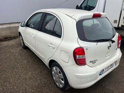 a small white car parked in a parking lot