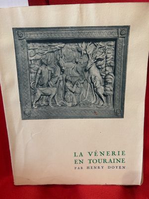 un vieux livre posé sur une table recouverte d'un tissu rouge