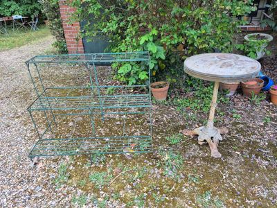 a small table with a birdbath on it in the yard
