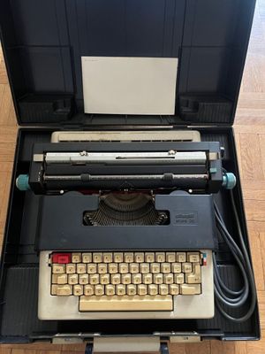 an old typewriter sitting in a case on the floor
