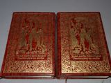 pair of red and gold book covers with figures on them