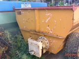 un camion-benne jaune garé dans l'herbe