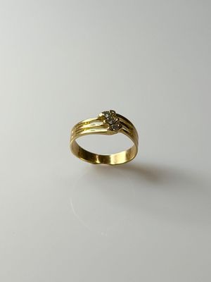 a close up of a gold ring with a diamond on it
