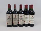 six bottles of wine are lined up in a row on a white surface