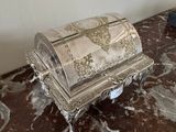 une boîte en argent posée sur une table en marbre
