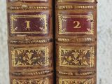 two old books sitting on top of a table next to each other