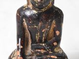 statue représentant une personne assise en position de méditation sur une surface blanche