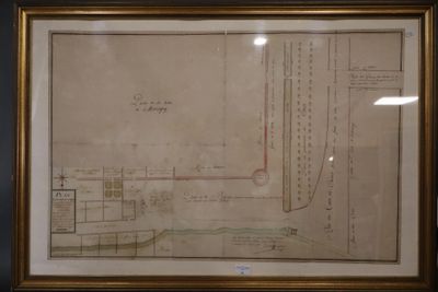 un vieux dessin représentant un plan, encadré et accroché au mur