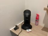 a coffee maker on a small desk in the corner of a room