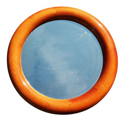 un miroir rond en bois dans lequel se reflète le ciel