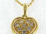 a yellow gold heart shaped pendant with diamonds on a chain