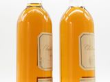 two bottles of wine sitting next to each other on a white surface