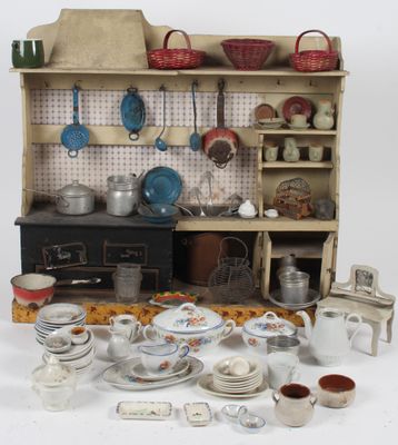 une cuisine de maison de poupées avec de nombreux objets posés sur la table