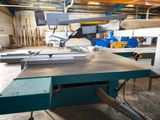 a machine that is cutting a piece of wood in a factory