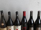 several bottles of wine are lined up on a wooden table
