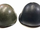 two helmets are sitting next to each other on a white surface