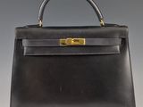 un sac à main en cuir noir avec des ferrures dorées sur la poignée