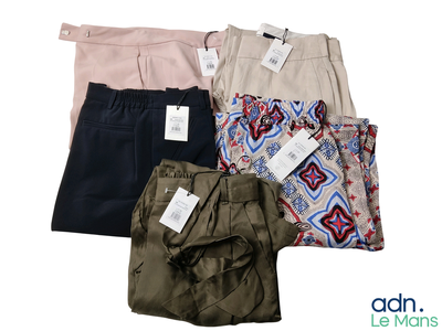 quatre paires de pantalons et une chemise sur fond blanc