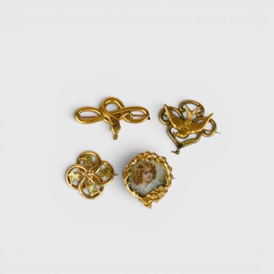 a group of three gold and enamel brooches