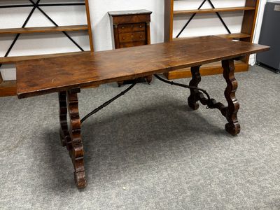 une longue table avec un plateau en bois dans une pièce