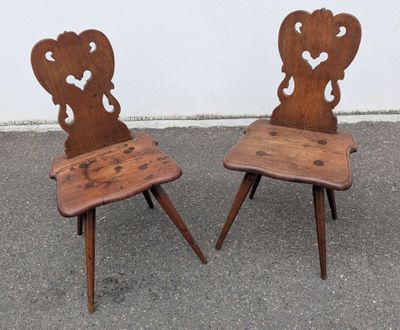 pair of antique wooden chairs with hearts on the backs