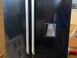 a black refrigerator sitting on a pallet in a warehouse
