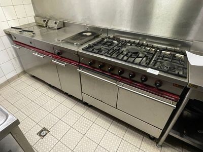 a large stainless steel kitchen with a stove and a sink