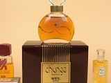 a bottle of perfume sitting on a table next to other bottles