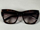 lunettes de soleil « œil de chat » noires et écaille sur un fond blanc