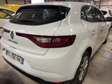 a white car parked in a garage with other cars in the background
