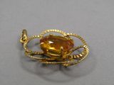 une image représentant une broche en or ornée d'une citrine au centre