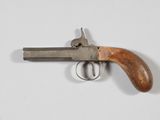 un vieux pistolet avec une poignée en bois sur une surface blanche