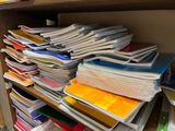 a lot of folders stacked on a shelf in a room