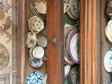 a wooden cabinet with plates on it in a room