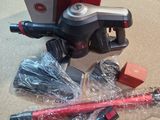 a red and black vacuum on a counter next to a package of tools