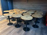 many tables and stools in a room with wood walls