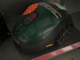 un aspirateur vert et noir posé sur une étagère dans un magasin