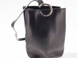 black leather bucket bag with metal ring handle on white background