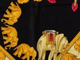a black and gold scarf with a picture of elephants on it