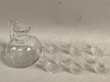 Des bouteilles et des verres sont alignés à côté d'une carafe sur une table