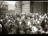 black and white photograph of a crowd of people standing in front of a building