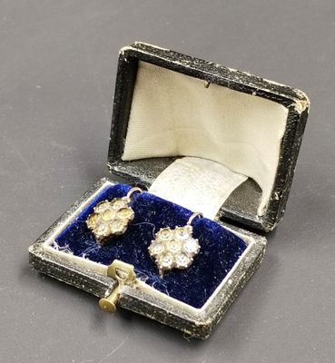 une photo représentant une paire de boucles d'oreilles dans une boîte posée sur une table