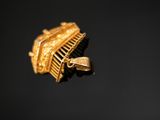 a gold brooch on a black surface