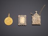 three gold and silver pendants and a gold coin