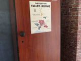 un réfrigérateur sur lequel est accrochée une affiche, devant un mur de briques